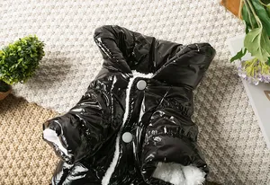 Dettaglio di un piumino nero lucido per cani con morbida fodera in pile bianco caldo