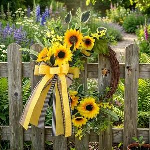 Autumn artificial sunflower wreath with yellow bow hanging on a rustic garden fence