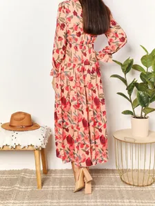 Back view of a long-sleeved floral print maxi dress with a tiered skirt design