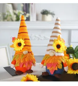 Detailansicht von zwei herbstlichen Wichteln mit Sonnenblumen und Ahornblättern