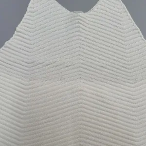 Close-up detail of a white halter knitted vest featuring a textured chevron pattern