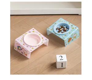 Detailed view of pink and blue ceramic pet bowls with inclined acrylic cartoon stands