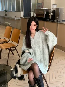 Primo piano di un maglione oversize a trecce verde menta indossato da una modella