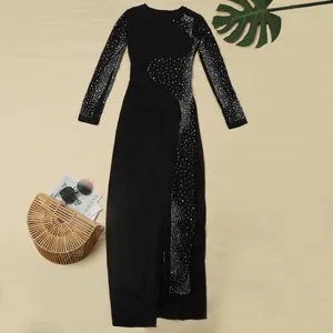 Elegante abito lungo nero a maniche lunghe con strass brillanti e un spacco alto.