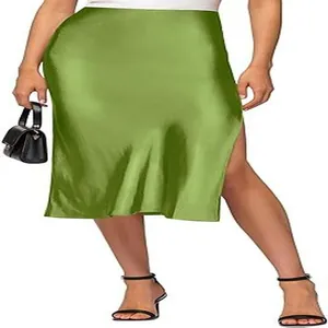 Detail of a green satin high-waisted midi skirt with a side slit and elastic waist.