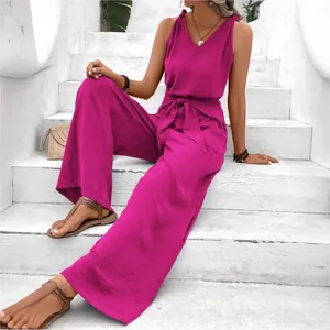 Elegant V-neck sleeveless wide-leg jumpsuit with a knotted waist belt in magenta.