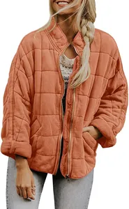 Close-up of terracotta women's quilted jacket featuring stand collar and zipper closure.