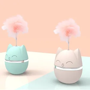 Close-up of cute cat-shaped tumbler toys featuring pink feathers and spring attachments