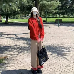 Cardigan rouge en tricot de style collège porté par un mannequin dans un parc extérieur vue