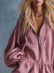 Detail view of a pink leopard print mini dress featuring a front zipper and ruffled hem design.