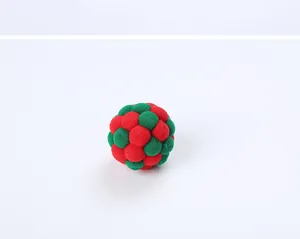 Close-up of a handmade red and green plush pom-pom ball toy for cats and pets.