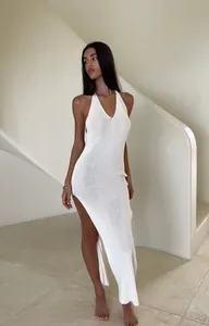 Sophisticated white knit halter maxi dress featuring a high side slit for resort beachwear