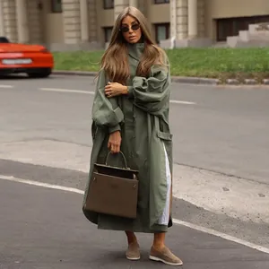 Detailed view of an oversized army green long trench coat featuring lantern sleeves and slits