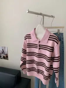 Vue détaillée d'un pull en maille à rayures rose et marron avec col polo sur cintre.