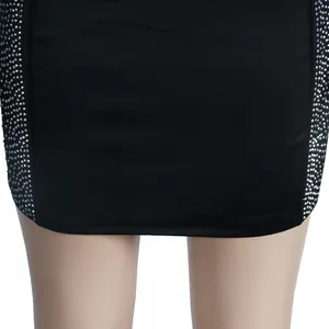 Detail view of sparkly silver rhinestones on the side panels of a slim black dress