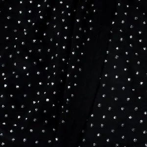 Primer plano de detalles de diamantes de imitación plateados sobre tela negra de alta calidad
