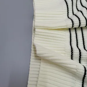 Detailed close-up view of a soft white striped knit sweater showing ribbed texture