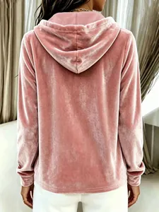 Detail view of the back of a pink velvet hooded sweatshirt with soft velour texture