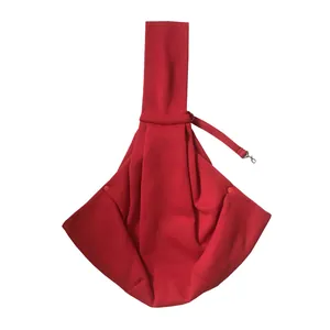 Detail showing the red pet sling carrier's shoulder strap and safety leash clip.