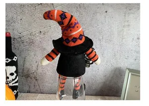 Detailed view of a Halloween gnome doll with a tall striped hat and long legs.