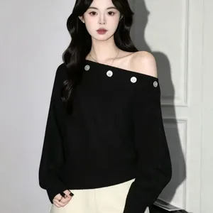 Elegante jersey de punto negro con hombros descubiertos, detalles de botones y ajuste holgado