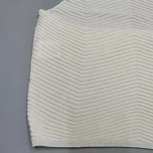 Close-up detail of a white knitted vest with zigzag texture and fine line patterns