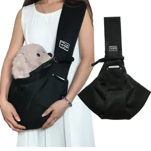Detailed view of the black pet sling carrier featuring a phone pocket and wide strap.