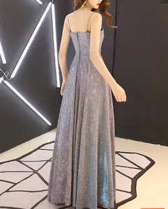 Rear view of an elegant sparkly silver-grey backless evening gown with thin straps