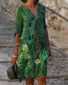 Elegant women's V-neck midi dress featuring a vibrant green floral pattern and mid-length sleeves