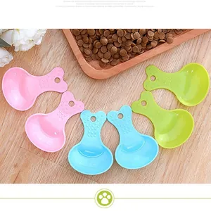 Colorful plastic pet food scoops in pink, blue and green for cat, dog and hamster food