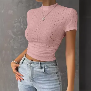 Détail du haut court en maille rose ajusté avec texture ajourée et fronces latérales