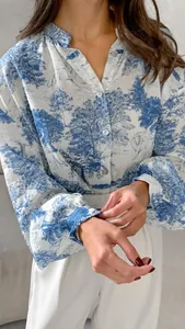 Macro detail of women's blue landscape print blouse with elegant lantern sleeves