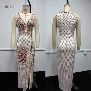 Vue de face et de dos d'une robe longue blanche sans manches à pois avec fente et motif floral.