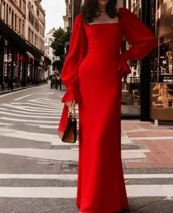 Elegant red long sleeve formal dress with ruffled cuffs in an outdoor street setting