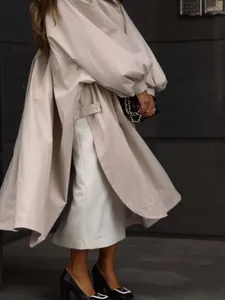 Elegant oversized beige trench coat with lantern sleeves and side slits detail.