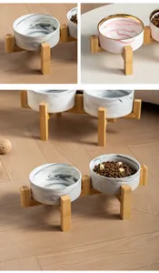 Vista dettagliata delle ciotole in ceramica marmorizzata con supporto rialzato in legno