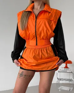 Casual two-piece sports set for women with orange zip jacket and black mini skirt