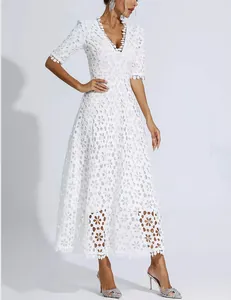 Detailed view of elegant white hollow-out lace maxi dress with deep V-neck and short sleeves