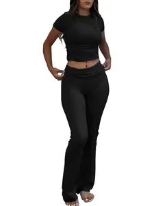 Women's black two-piece sports set featuring a round neck crop top and low waist flare pants