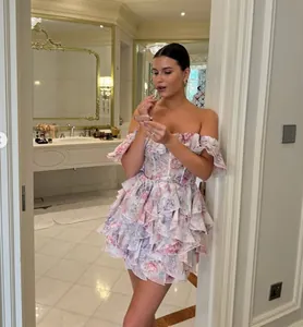 Model wearing a French floral off-the-shoulder ruffled mini dress in a luxury setting