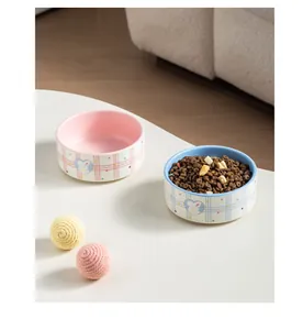 Lifestyle view of pink and blue ceramic pet bowls with cute rabbit illustrations