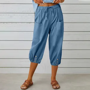 Detail of blue cotton linen cropped pants with drawstring waist and button hem.