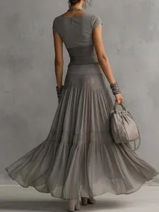 Back view of elegant grey knitted top and flowing pleated chiffon maxi skirt set
