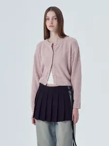 Fashionable woman wearing a soft light pink crew neck button-down knitted cardigan