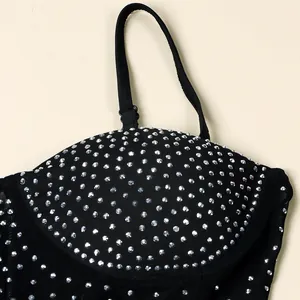 Detalle de cerca del top negro de fiesta con adornos de brillantes diamantes de imitación plata.