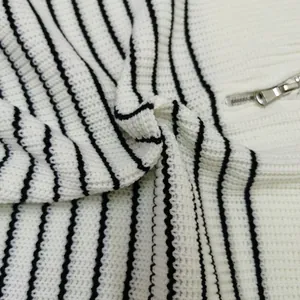 Detail view of the soft knit texture and silver half-zip on a striped sweater