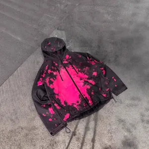 Macro detail of a black waterproof jacket with a pink heat-sensitive splash pattern.