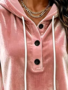 Close-up view of pink gold velvet hoodie showing button detail and soft fabric