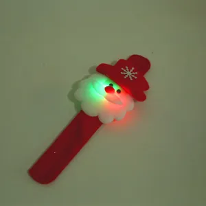 Close-up view of a glowing LED Christmas slap bracelet featuring a cute Santa design