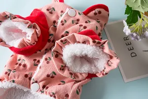 Detailopname van een roze huisdierjas met kersenpatroon en warme witte fleece voering